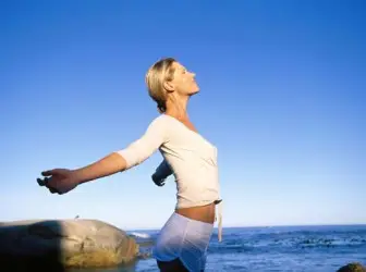 Woman stretching in yoga by the sea
